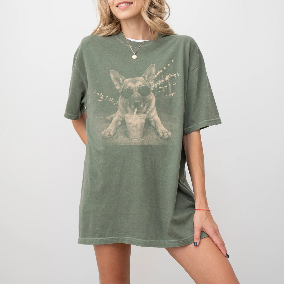 Model wearing a Moss Comfort Colors® T-shirt featuring German Shepherd with iced coffee in a retro grunge design