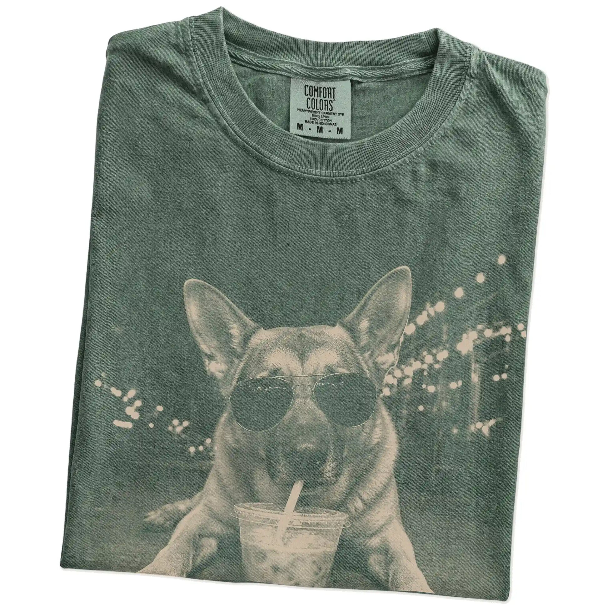 Folded Moss Comfort Colors® T-shirt showing German Shepherd with iced coffee in a retro grunge design