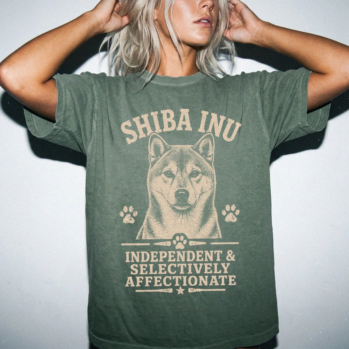Model wearing a Moss Comfort Colors® T-shirt featuring Shiba Inu design with “Independent & Selectively Affectionate” letteri