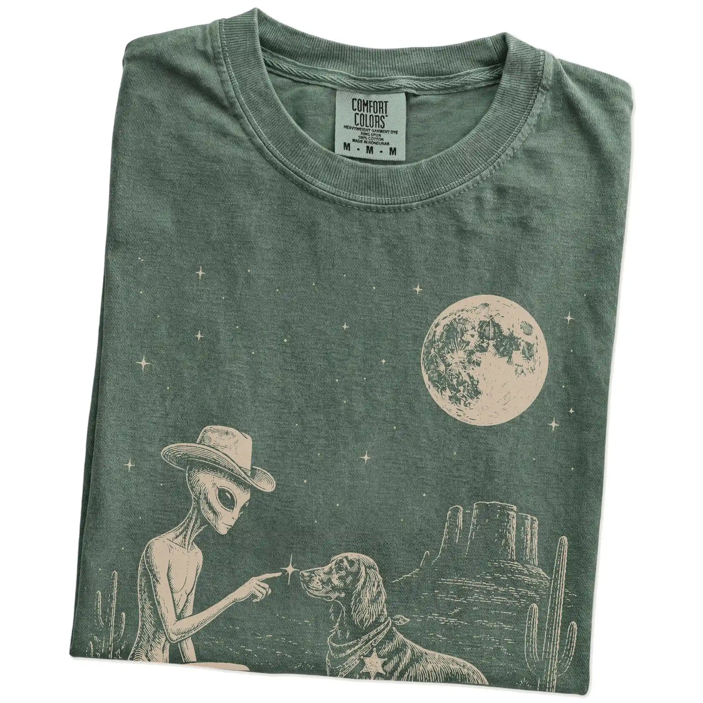 Folded Moss Comfort Colors® T-shirt showing cowboy alien fist-bumping a irish setter beneath the moon