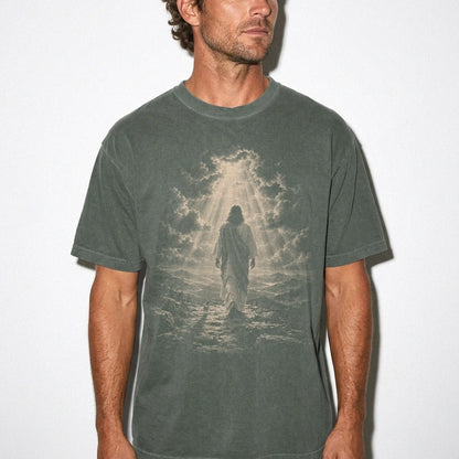 Person wearing a Moss T-shirt with Jesus walking beside a Chihuahua beneath rays of light
