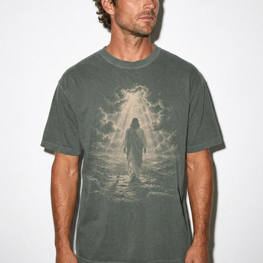 Person wearing a Moss T-shirt with Jesus walking beside a Chihuahua beneath rays of light