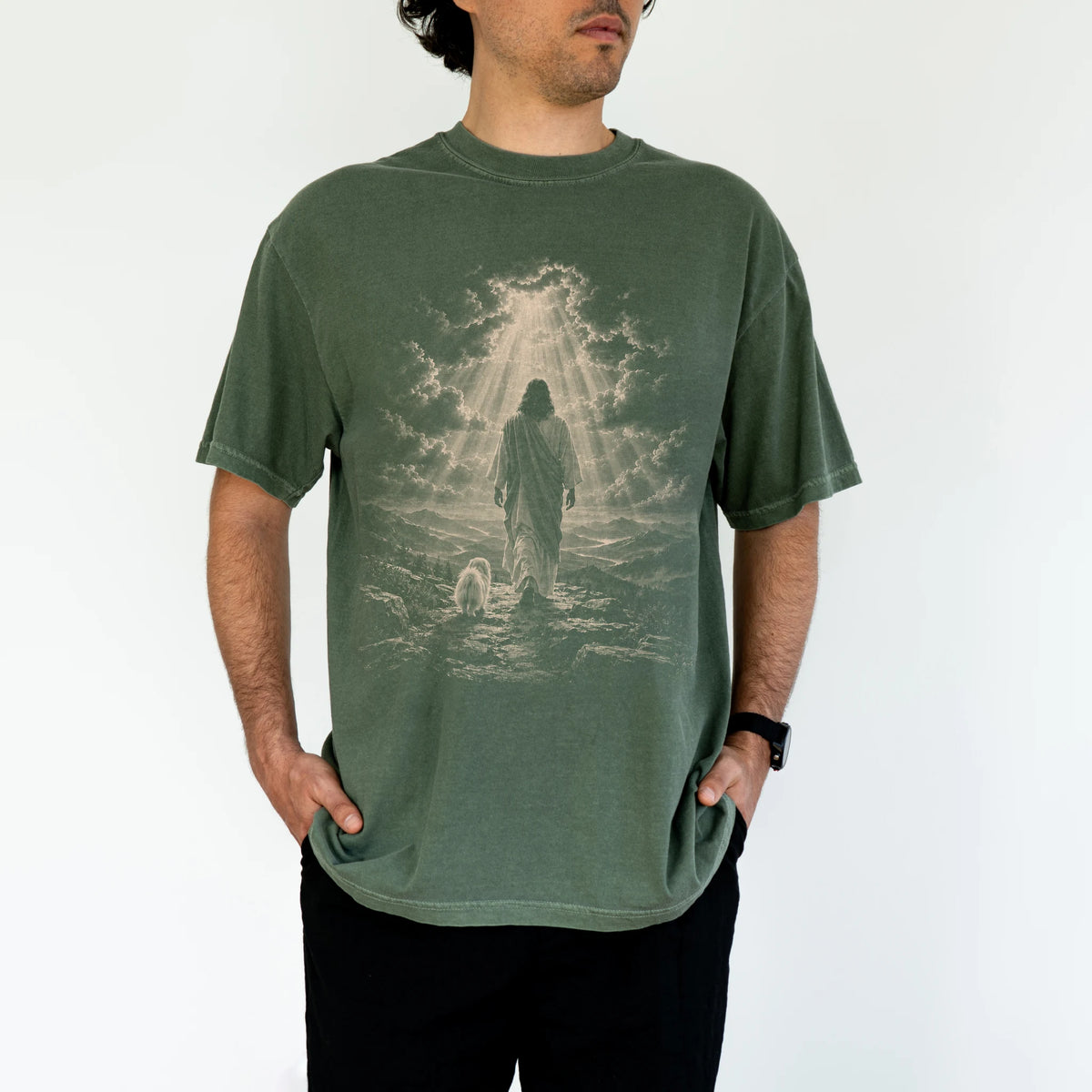 Person wearing a Moss T-shirt with Jesus walking beside a Maltese beneath rays of light