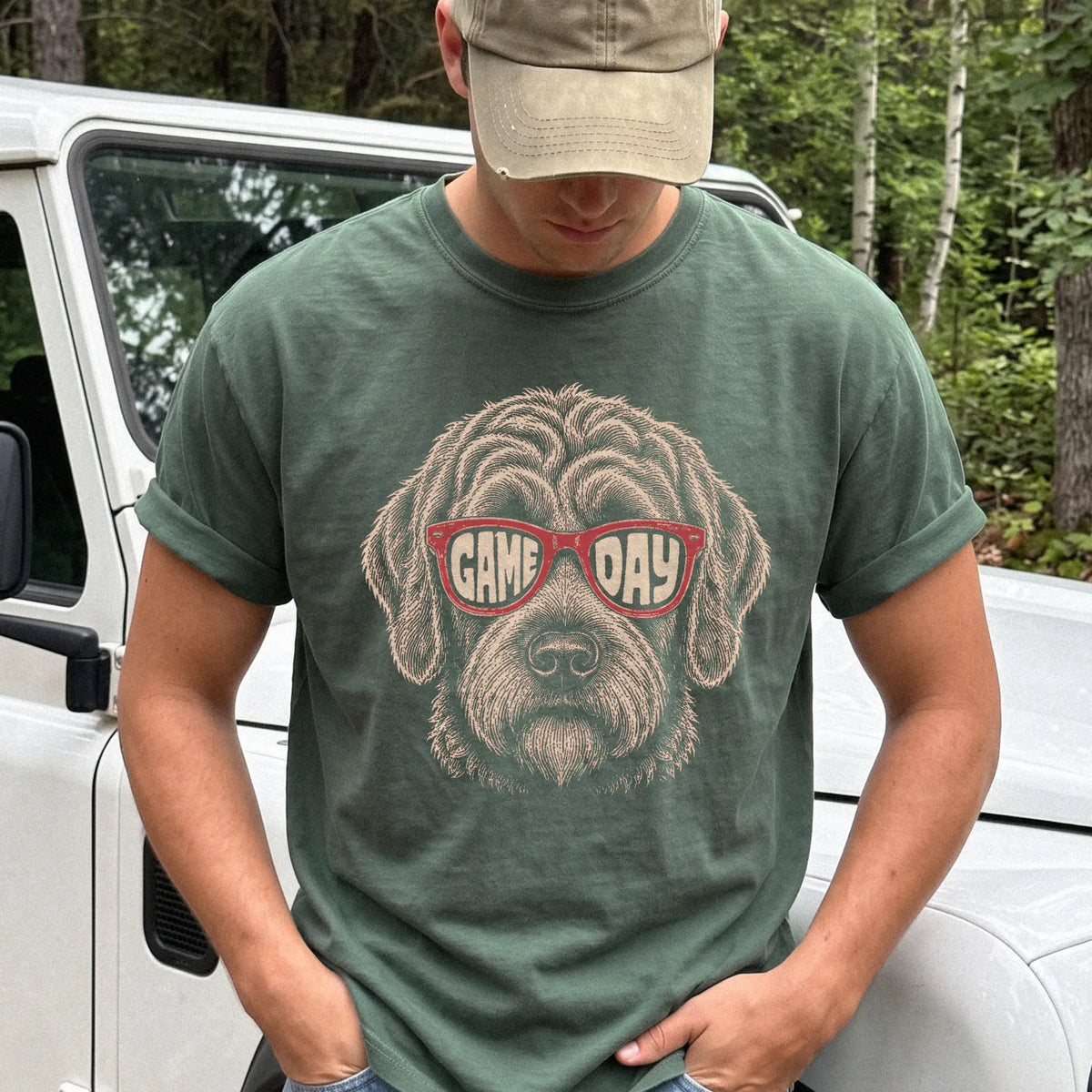 Model wearing a Moss Comfort Colors® T-shirt with labradoodle wearing red game day sunglasses