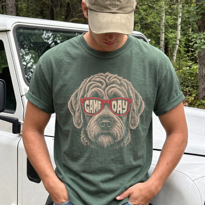 Model wearing a Moss Comfort Colors® T-shirt with labradoodle wearing red game day sunglasses