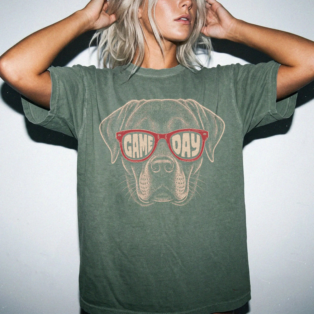 Model wearing a Moss Comfort Colors® T-shirt with labrador retriever wearing red game day sunglasses