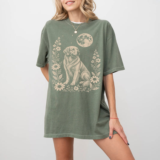 Model wearing a Moss Comfort Colors® T-shirt featuring Golden Retriever framed by flowers beneath the moon
