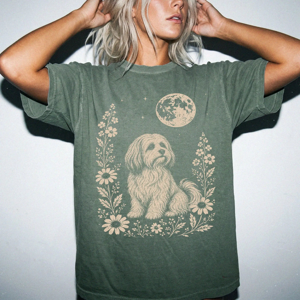Model wearing a Moss Comfort Colors® T-shirt featuring Havanese framed by flowers beneath the moon