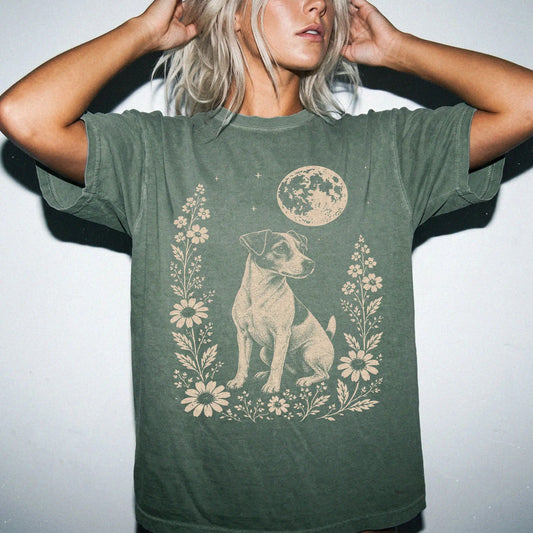 Model wearing a Moss Comfort Colors® T-shirt featuring Jack Russell framed by flowers beneath the moon