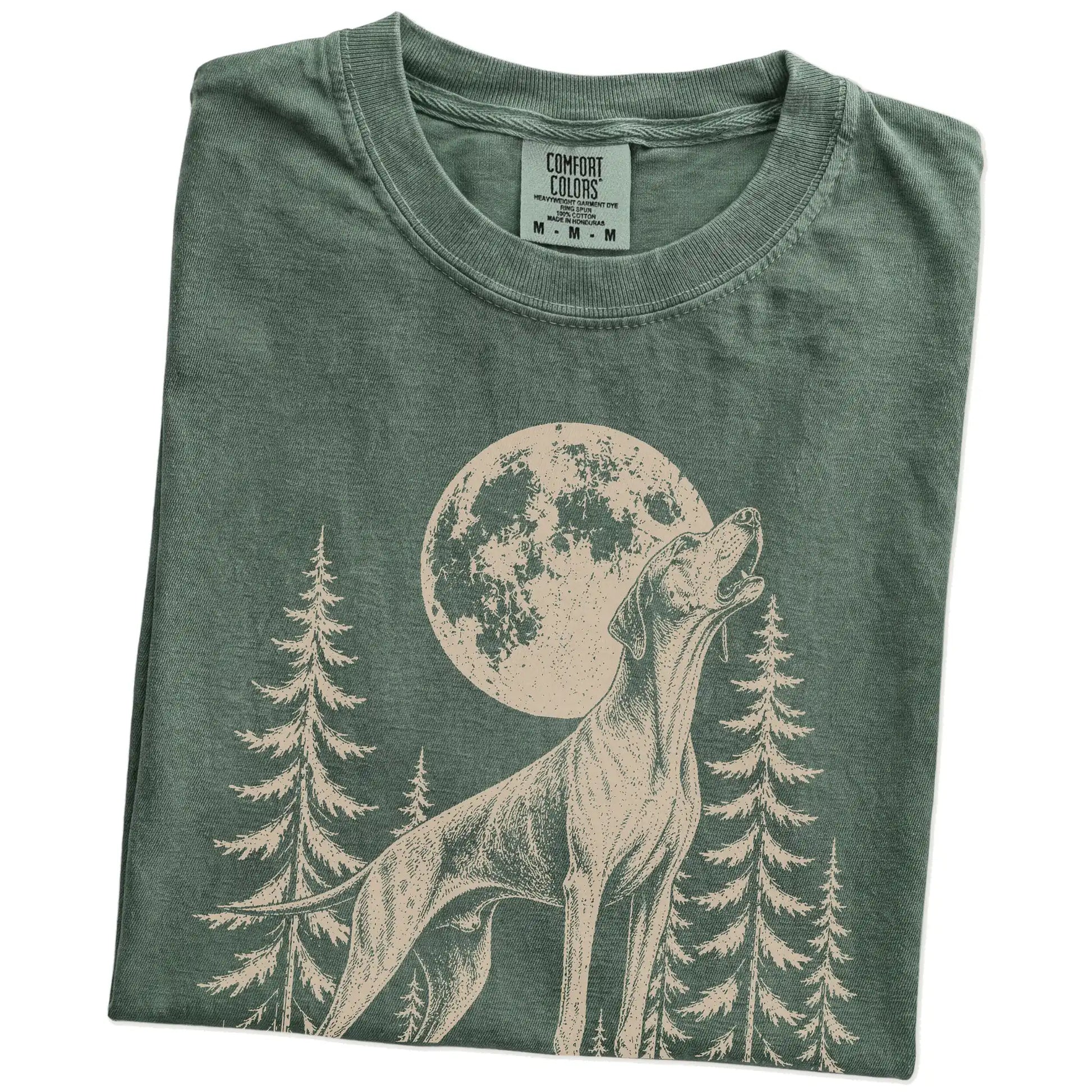 Folded Moss Comfort Colors® T-shirt showing a Pointer howling beneath the moon and pine trees