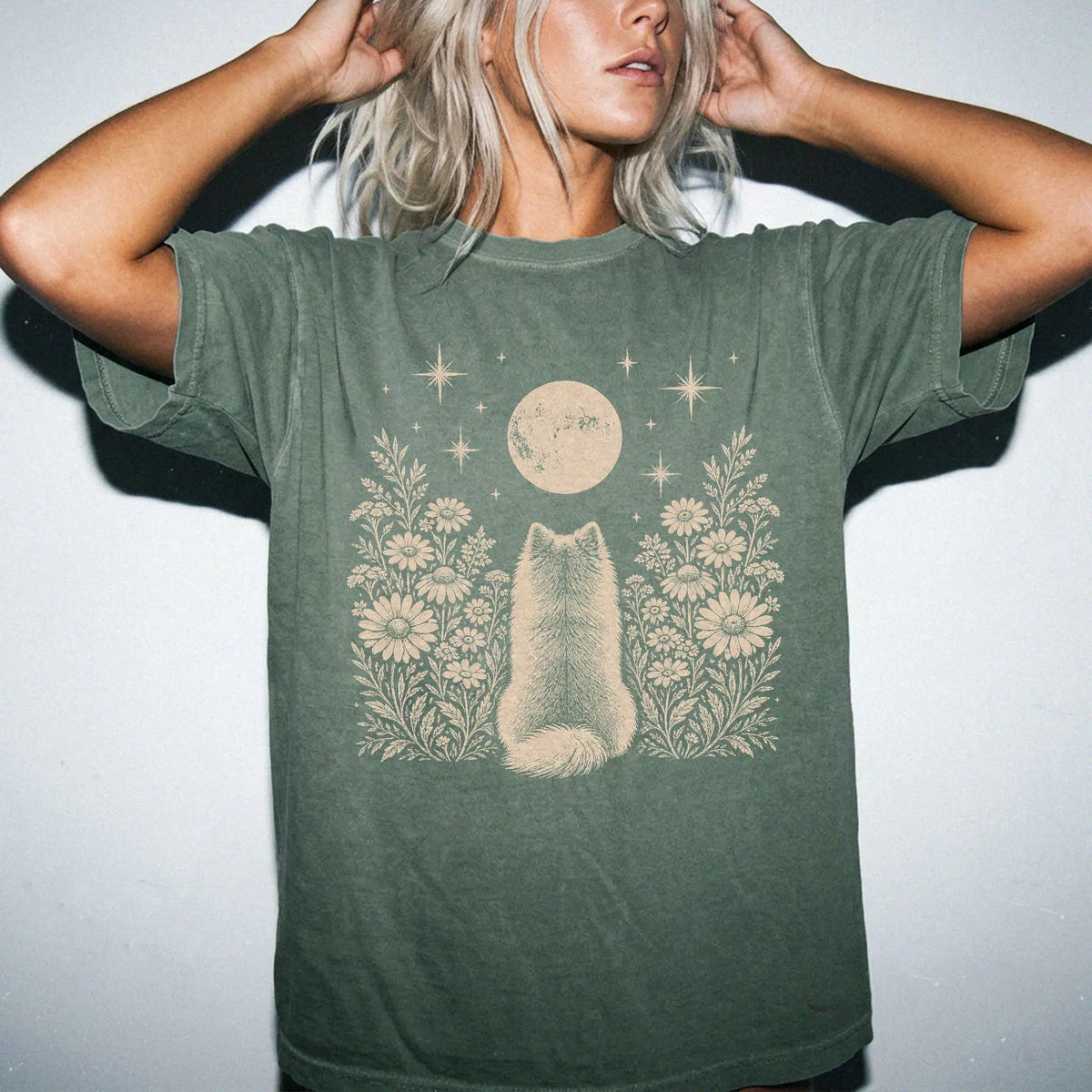 Model wearing a Moss Comfort Colors® T-shirt featuring Pomeranian beneath a wildflower moon