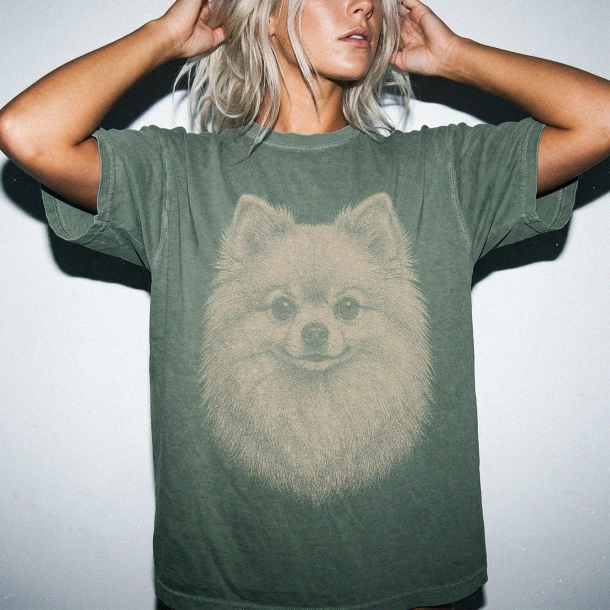 Model wearing a Moss Comfort Colors® T-shirt with a realistic drawing of a Pomeranian