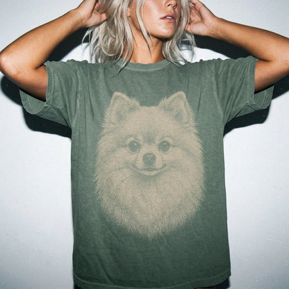 Model wearing a Moss Comfort Colors® T-shirt with a realistic drawing of a Pomeranian