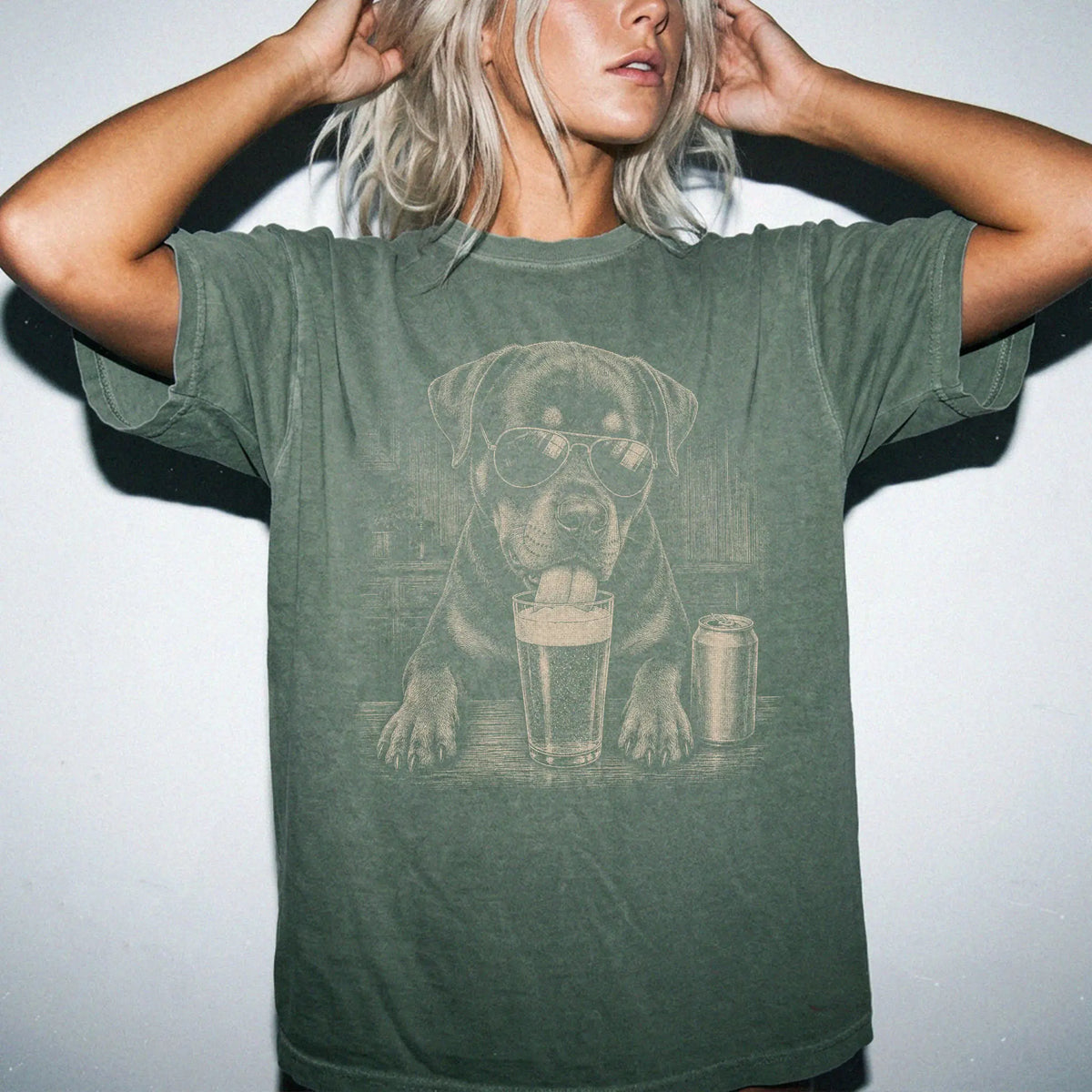 Model wearing a Moss Comfort Colors® t-shirt with Rottweiler sneaking a drink from a pint