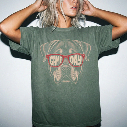 Model wearing a Moss Comfort Colors® T-shirt with rottweiler wearing red game day sunglasses