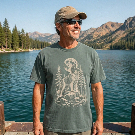 Model wearing a Moss Comfort Colors® T-shirt with a Saint Bernard howling beneath the moon and pine trees