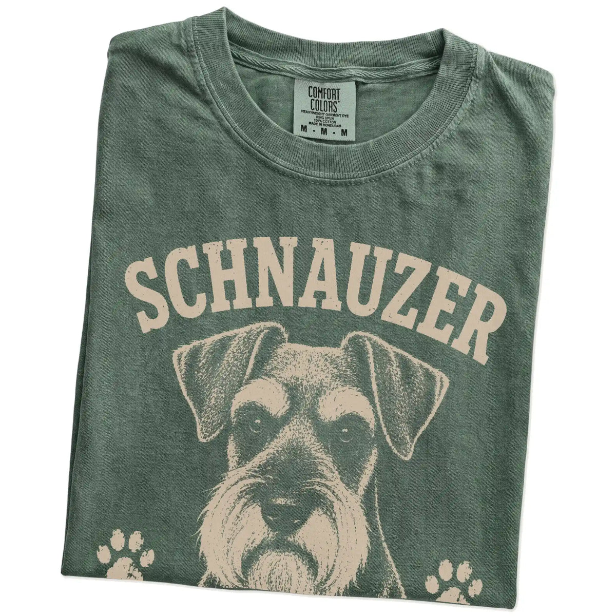 Folded Moss Comfort Colors® T-shirt showing Schnauzer design with “Serious Brows, Questionable Decisions” lettering