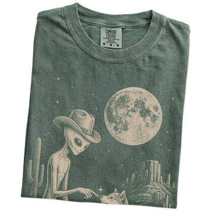 Folded Moss Comfort Colors® T-shirt showing cowboy alien fist-bumping a shiba inu beneath the moon