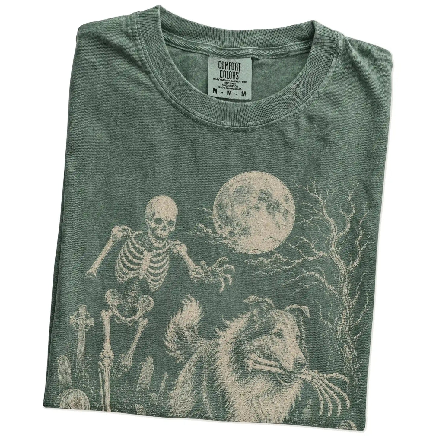 Folded Moss Comfort Colors® T-shirt showing Collie running through a moonlit graveyard with a chasing skeleton