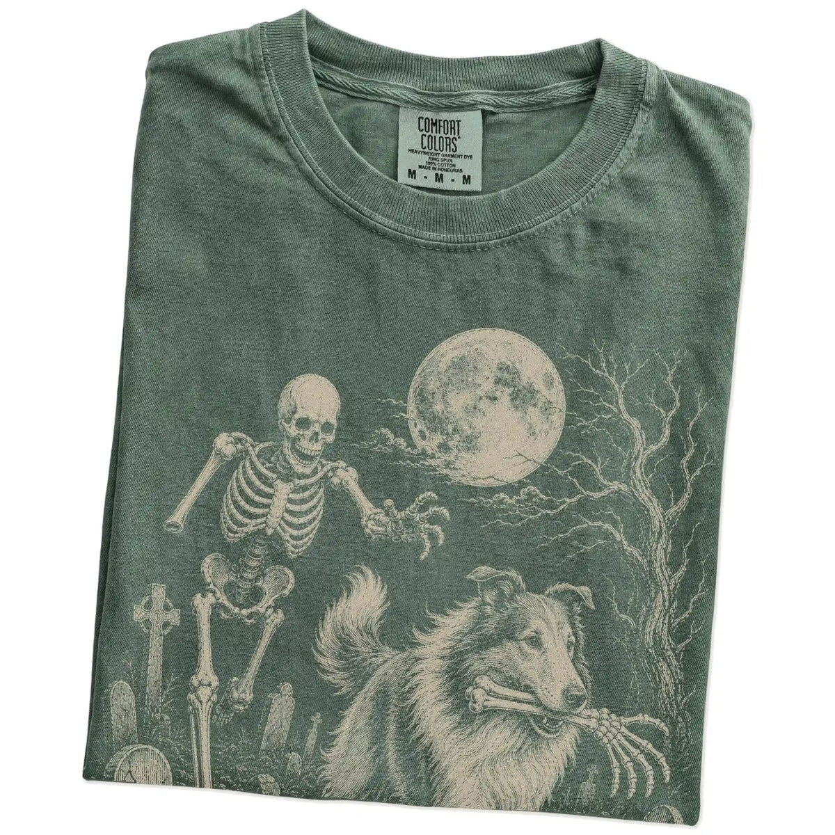 Folded Moss Comfort Colors® T-shirt showing Collie running through a moonlit graveyard with a chasing skeleton