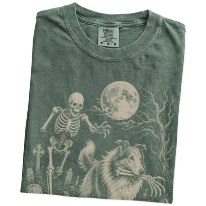 Folded Moss Comfort Colors® T-shirt showing Collie running through a moonlit graveyard with a chasing skeleton