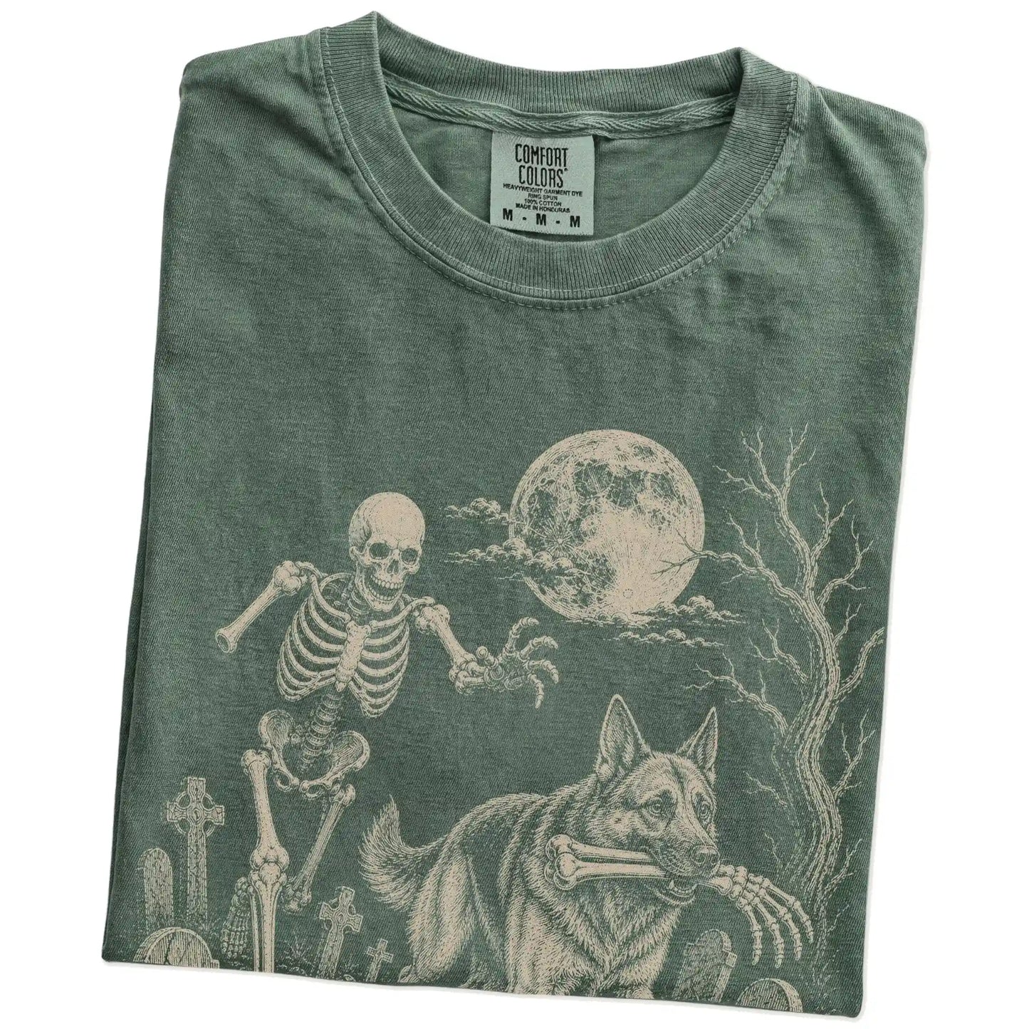Folded Moss Comfort Colors® T-shirt showing German Shepherd running through a moonlit graveyard with a chasing skeleton