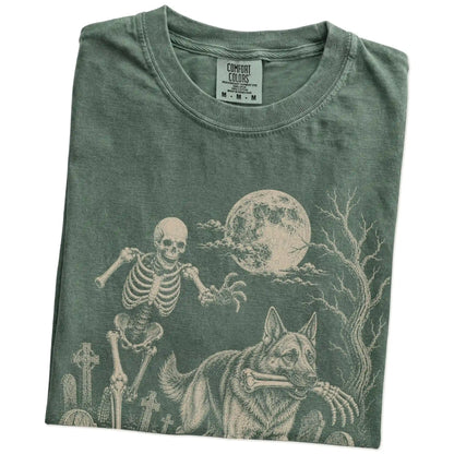 Folded Moss Comfort Colors® T-shirt showing German Shepherd running through a moonlit graveyard with a chasing skeleton