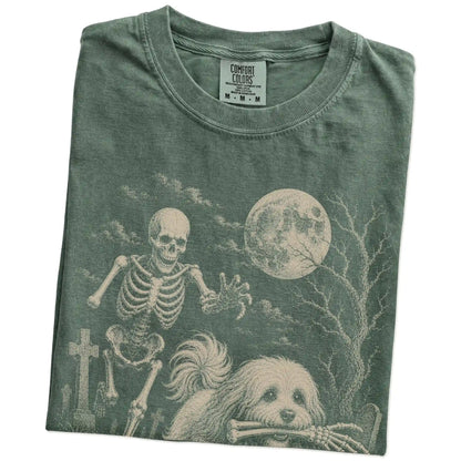 Folded Moss Comfort Colors® T-shirt showing Havanese running through a moonlit graveyard with a chasing skeleton