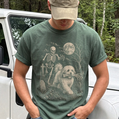 Model wearing a Moss Comfort Colors® T-shirt showing Havanese running through a moonlit graveyard with a chasing skeleton