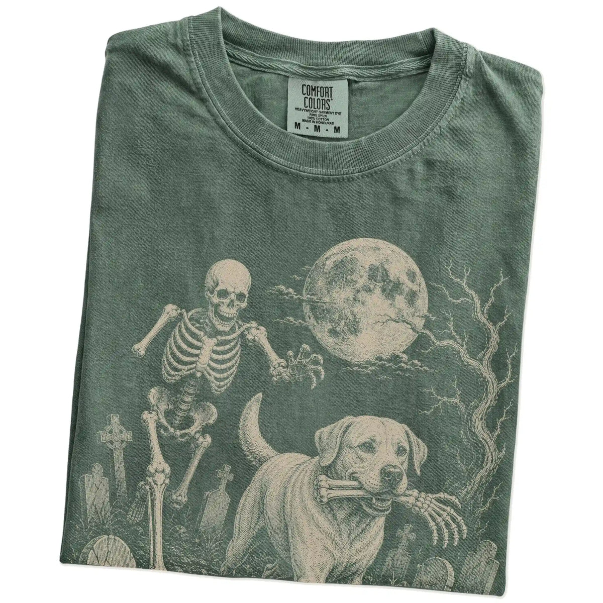 Folded Moss Comfort Colors® T-shirt showing Labrador Retriever running through a moonlit graveyard with a chasing skeleton
