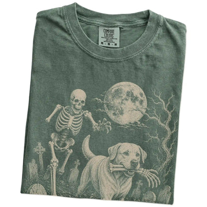 Folded Moss Comfort Colors® T-shirt showing Labrador Retriever running through a moonlit graveyard with a chasing skeleton