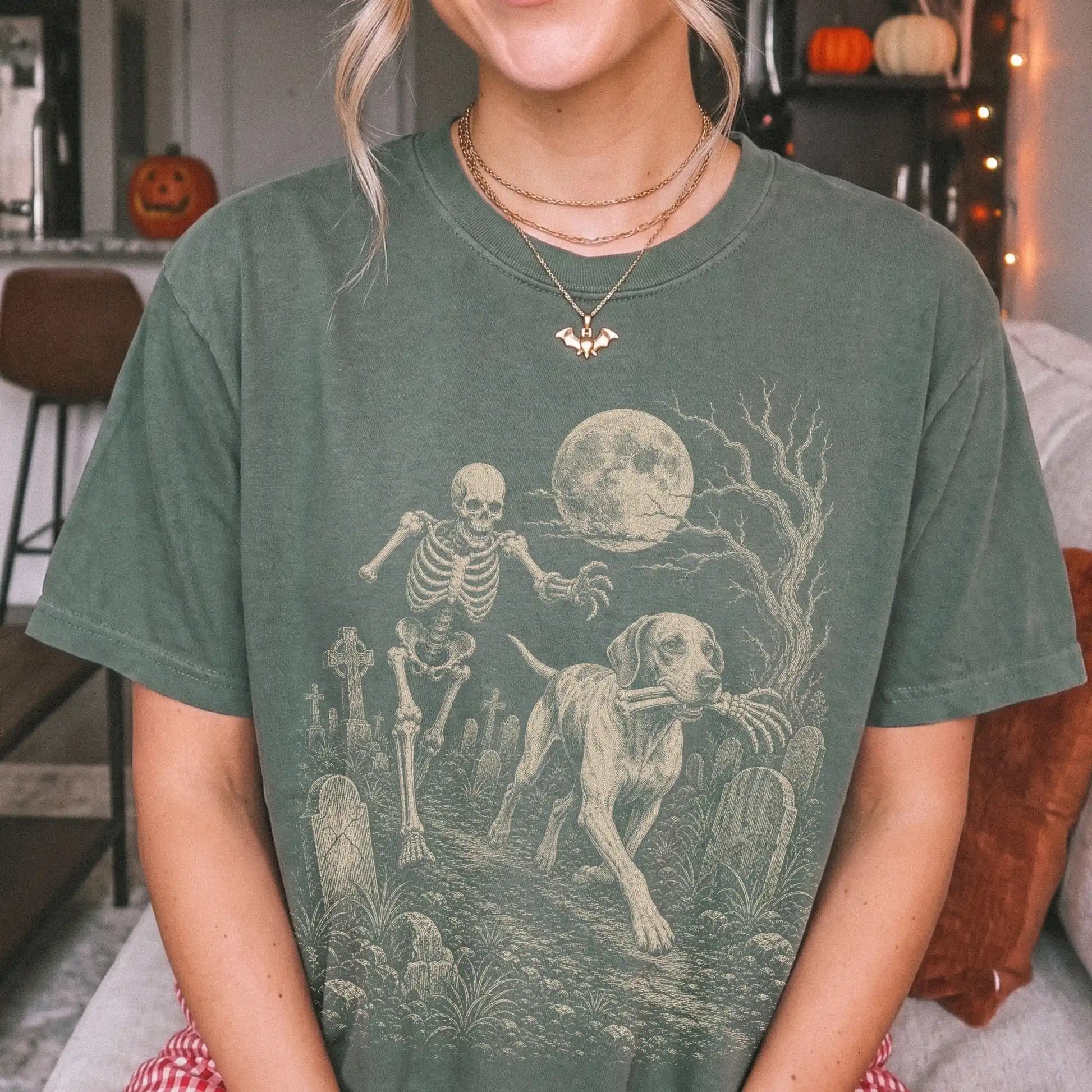 Model wearing a Moss Comfort Colors® T-shirt showing Pointer running through a moonlit graveyard with a chasing skeleton
