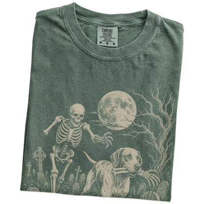 Folded Moss Comfort Colors® T-shirt showing Pointer running through a moonlit graveyard with a chasing skeleton