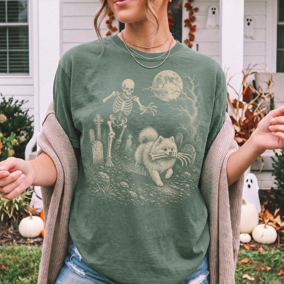 Model wearing a Moss Comfort Colors® T-shirt showing Pomeranian running through a moonlit graveyard with a chasing skeleton