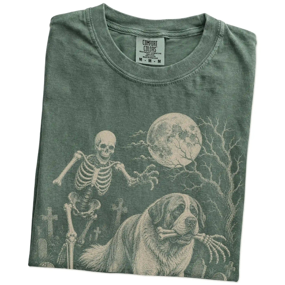 Folded Moss Comfort Colors® T-shirt showing Saint Bernard running through a moonlit graveyard with a chasing skeleton