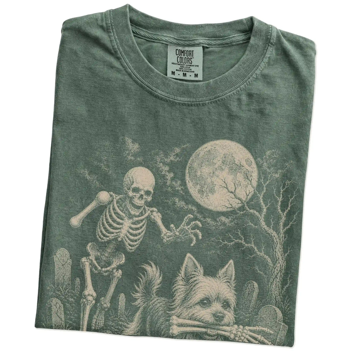 Folded Moss Comfort Colors® T-shirt showing Yorkie running through a moonlit graveyard with a chasing skeleton