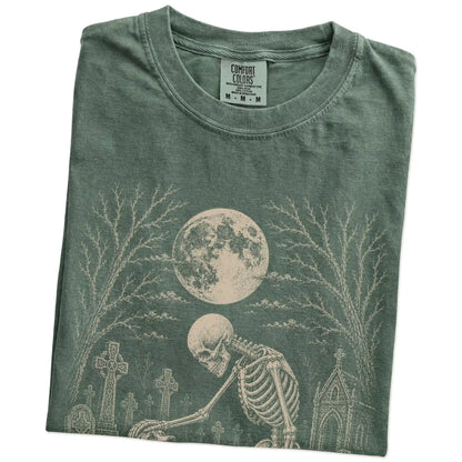 Folded Moss Comfort Colors® T-shirt showing Beagle sharing a quiet cemetery moment with a friendly skeleton