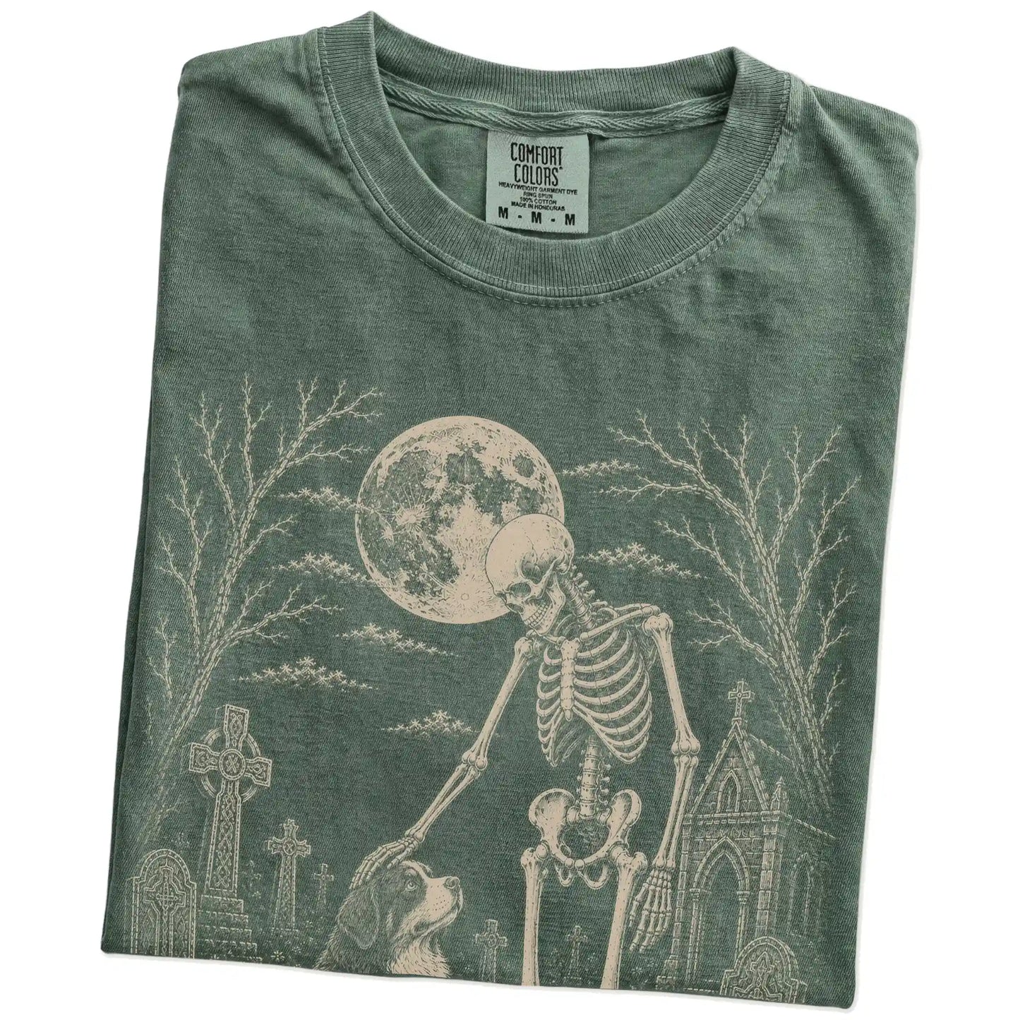 Folded Moss Comfort Colors® T-shirt showing Bernese Mountain Dog sharing a quiet cemetery moment with a friendly skeleton