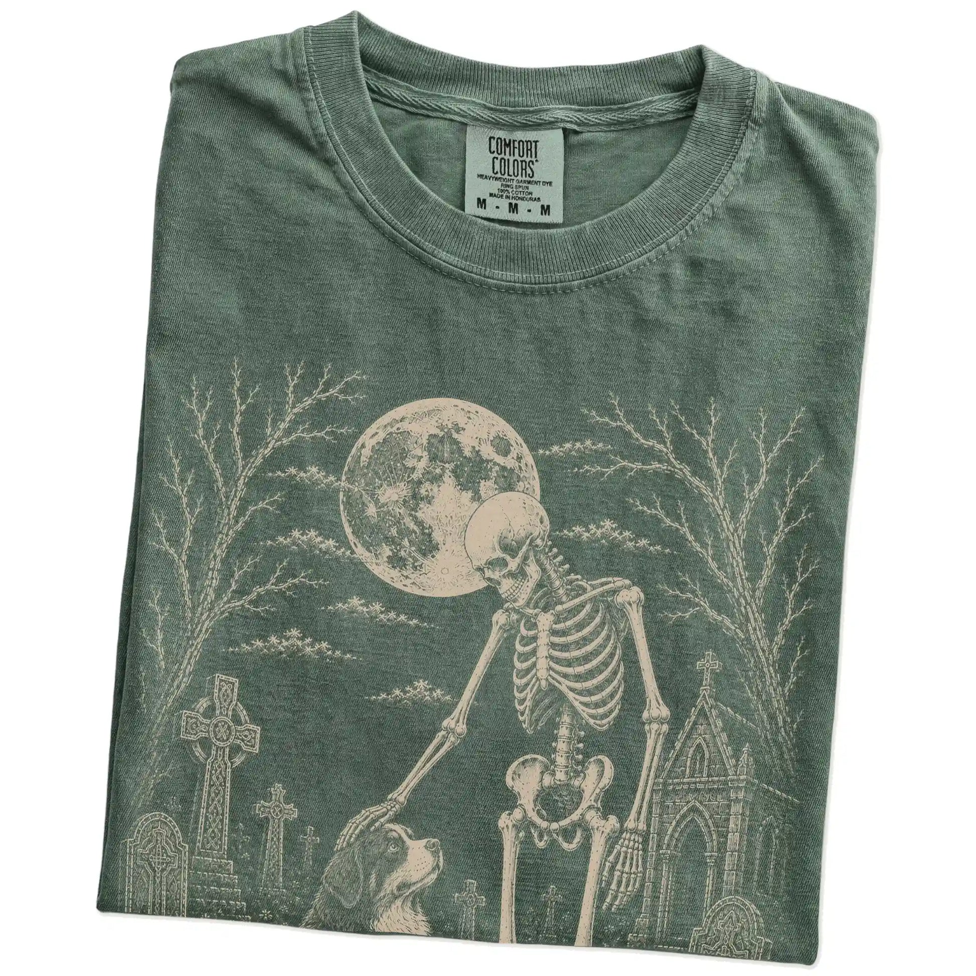 Folded Moss Comfort Colors® T-shirt showing Bernese Mountain Dog sharing a quiet cemetery moment with a friendly skeleton