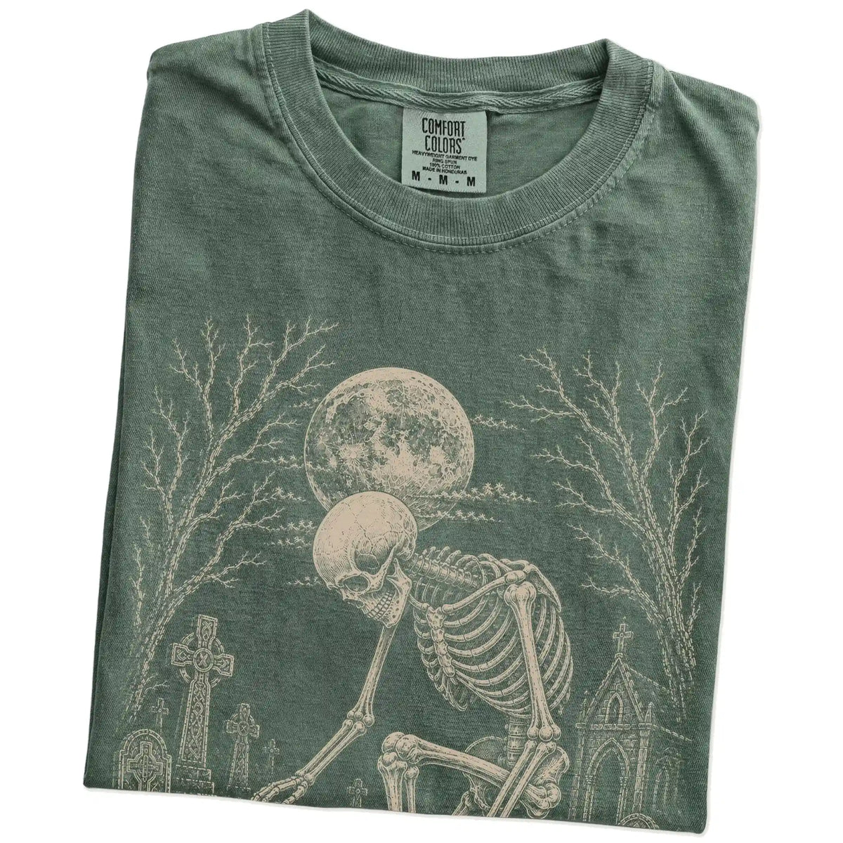 Folded Moss Comfort Colors® T-shirt showing Havanese sharing a quiet cemetery moment with a friendly skeleton