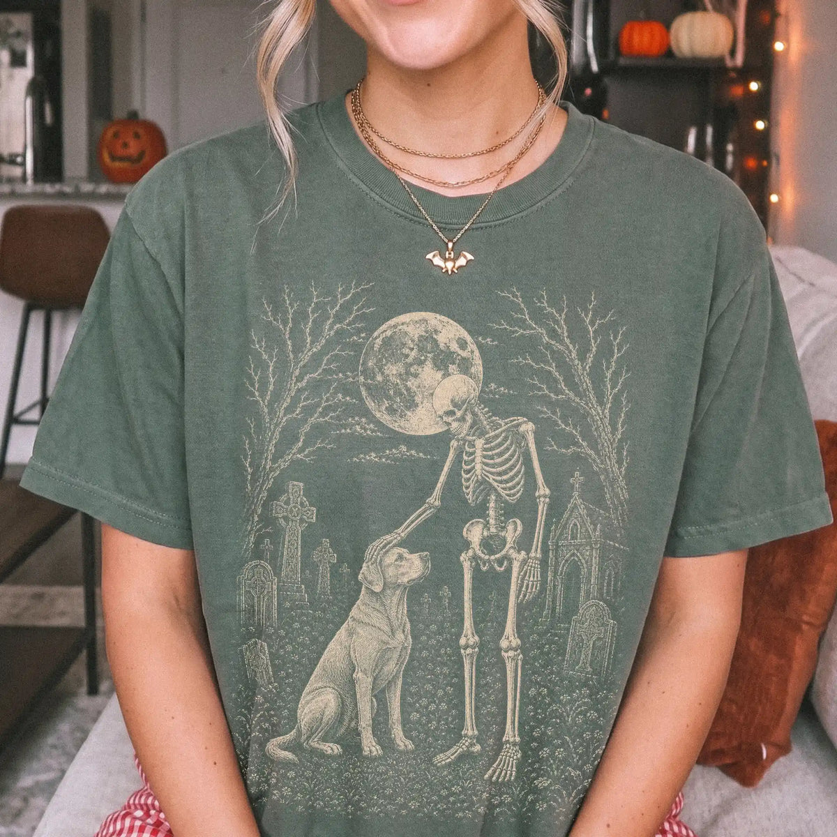 Model wearing a Moss Comfort Colors® T-shirt showing Labrador Retriever sharing a quiet cemetery moment with a friendly skele