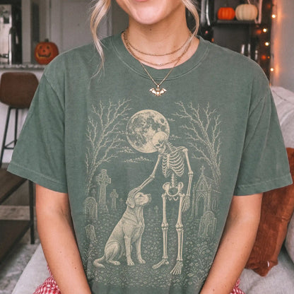 Model wearing a Moss Comfort Colors® T-shirt showing Labrador Retriever sharing a quiet cemetery moment with a friendly skele