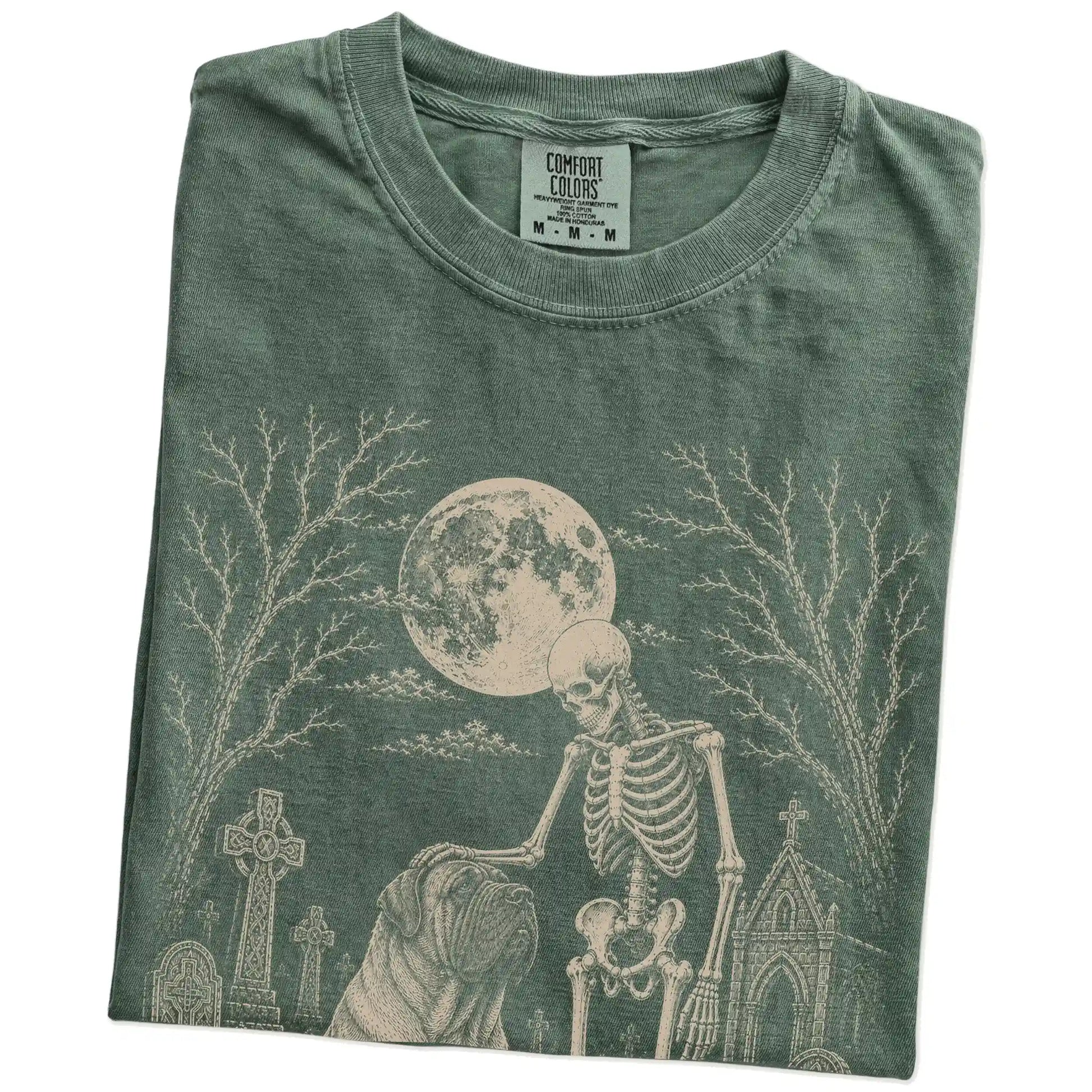 Folded Moss Comfort Colors® T-shirt showing Mastiff sharing a quiet cemetery moment with a friendly skeleton