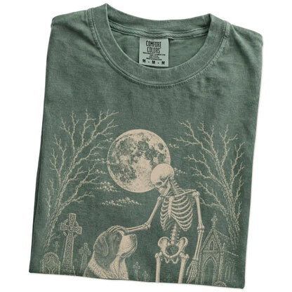 Folded Moss Comfort Colors® T-shirt showing Saint Bernard sharing a quiet cemetery moment with a friendly skeleton