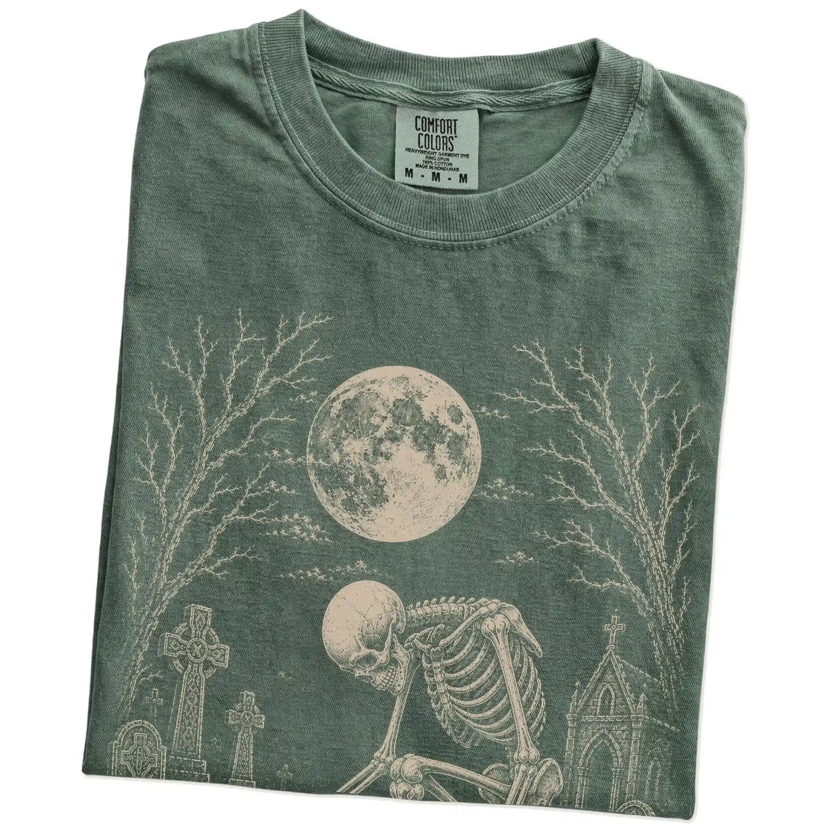 Folded Moss Comfort Colors® T-shirt showing Westie sharing a quiet cemetery moment with a friendly skeleton