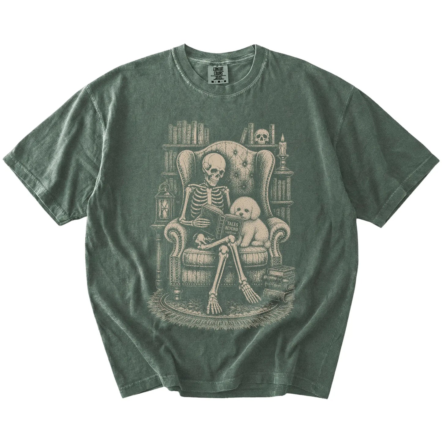 Skeleton reading in a library beside a Bichon Frise on a Moss Comfort Colors® T-shirt