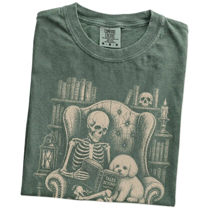 Folded Moss Comfort Colors® T-shirt showing skeleton reading in a library beside a Bichon Frise