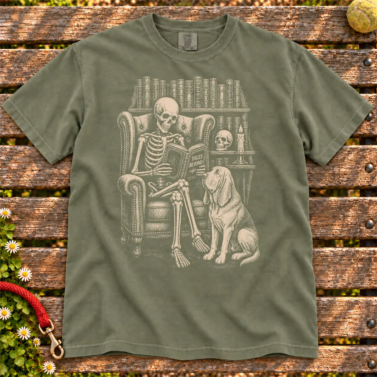 Skeleton reading in a library beside a Bloodhound on a Moss Comfort Colors® T-shirt