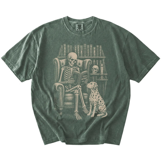 Skeleton reading in a library beside a Dalmatian on a Moss Comfort Colors® T-shirt