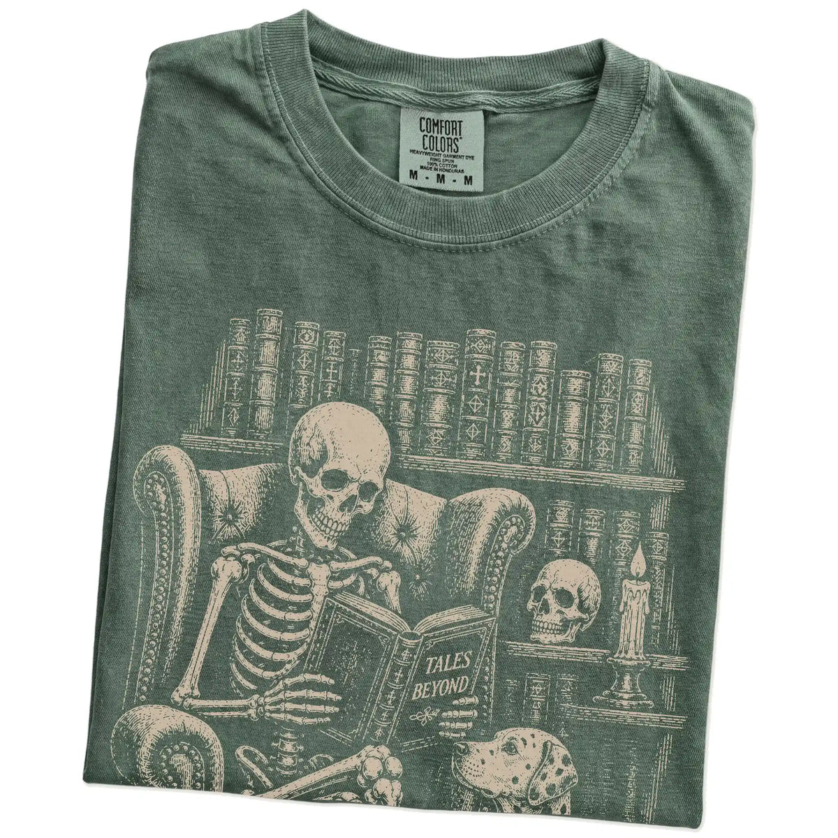 Folded Moss Comfort Colors® T-shirt showing skeleton reading in a library beside a Dalmatian